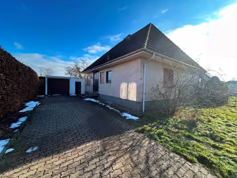 Zwangsversteigerung Einfamilienhaus in Minden, Todtenhausen – Nordwestansicht des Hauses mit gepflasterter Zufahrt und Garage.