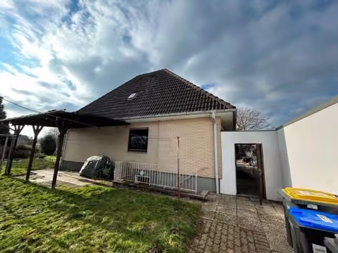 Zwangsversteigerung Einfamilienhaus in Minden, Todtenhausen – Ostansicht der Gebäuderückseite mit Hofbereich und Kellertreppe.