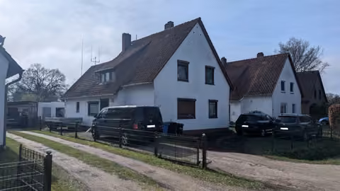 Zwangsversteigerung Einfamilienhaus in Osterholz-Scharmbeck – Straßenseitige Außenansicht des freistehenden Einfamilienhauses mit Vorplatz.