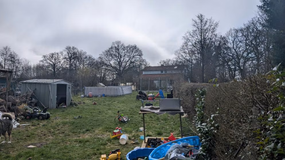 Zwangsversteigerung Einfamilienhaus in Osterholz-Scharmbeck – Rückseitige Gebäudeansicht mit Zugangsbereich und Anbau.
