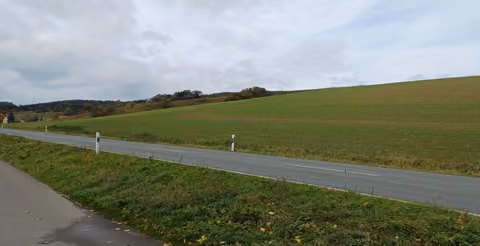 Zwangsversteigerung Landwirtschaft in Saara, Geißen – Blick von der angrenzenden Straße auf das landwirtschaftlich genutzte Ackerland.