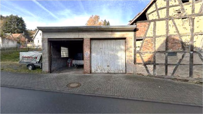 Zwangsversteigerung Einfamilienhaus in Schmitten, Arnoldshain – Doppelgarage mit manuellen Toren und Vorplatz.