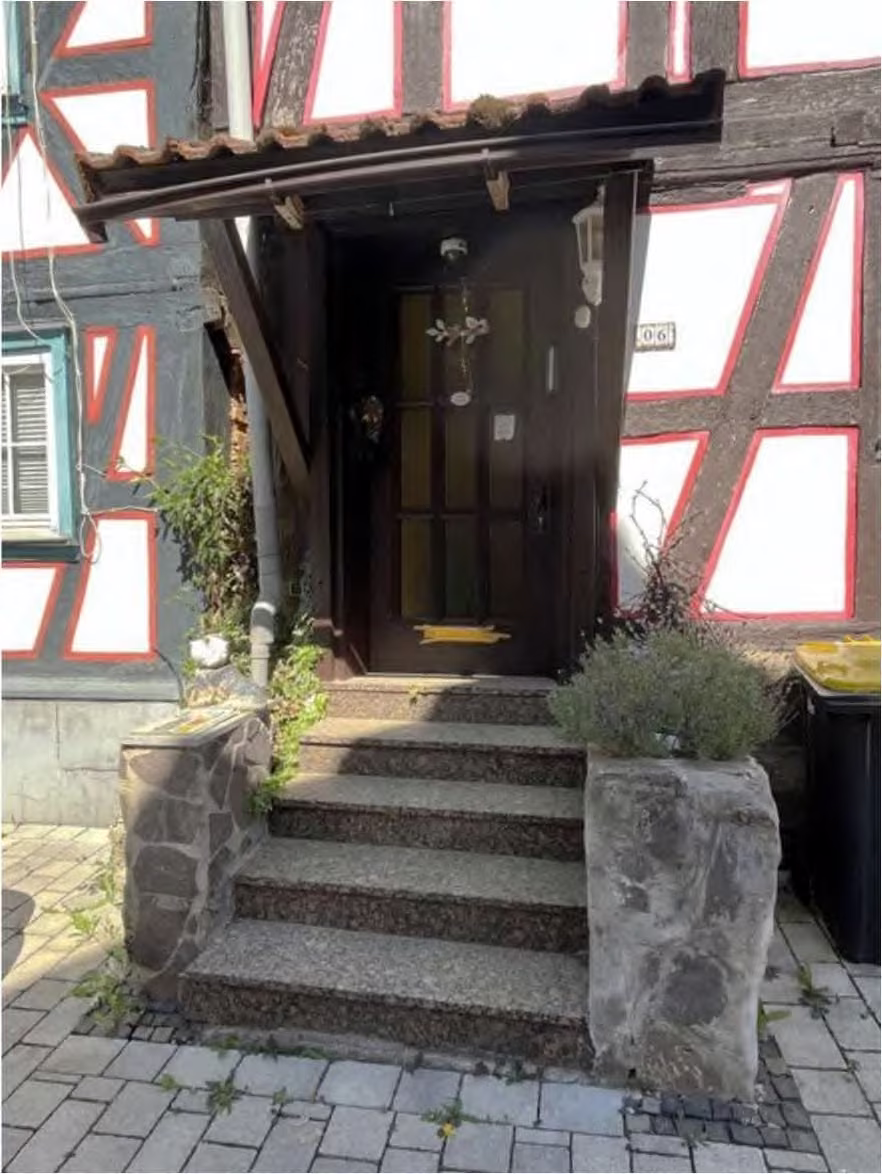 Zwangsversteigerung Einfamilienhaus in Schotten – Detailansicht der überdachten Eingangstreppe im Straßenraum.