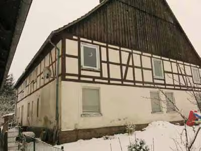 Zwangsversteigerung Zweifamilienhaus in Bad Driburg, Reelsen – Ansicht des Zweifamilienhauses von Nordosten mit Fachwerkobergeschoss im Winter.