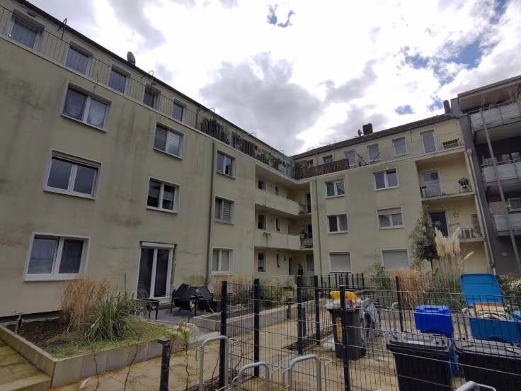 Zwangsversteigerung Eigentumswohnung in Krefeld, Mitte – Rückseitige Ansicht der Wohnanlage und des begrünten Innenhofbereichs.