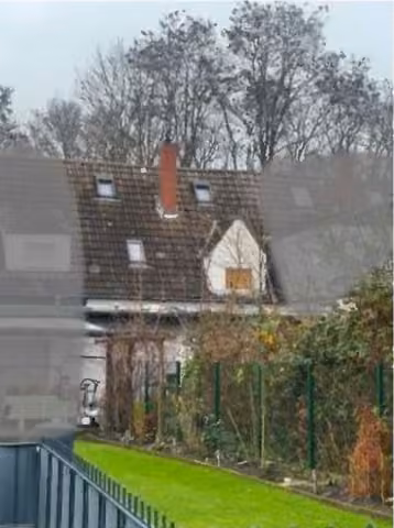 Zwangsversteigerung Reihenhaus in Lünen, Horstmar – Gartenansicht des Objekts mit Dachflächen und rückwärtigem Anbau.
