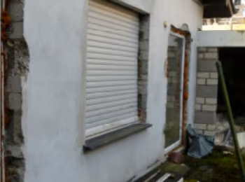 Zwangsversteigerung Einfamilienhaus in Schleiden, Olef – Detailansicht der Gebäudefassade und Fensterpartie im Erdgeschoss.