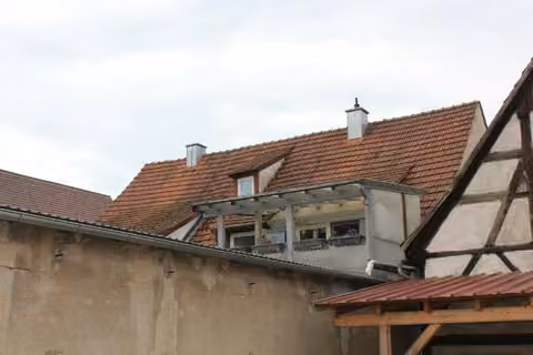 Zwangsversteigerung Einfamilienhaus in Ebermannstadt, Breitenbach – Rückansicht des Mittelhauses mit angebautem Balkon.