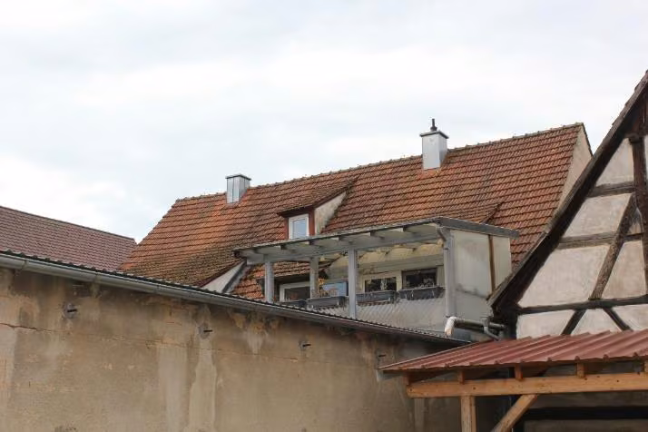 Zwangsversteigerung Einfamilienhaus in Ebermannstadt, Breitenbach – Rückansicht des Mittelhauses mit angebautem Balkon.
