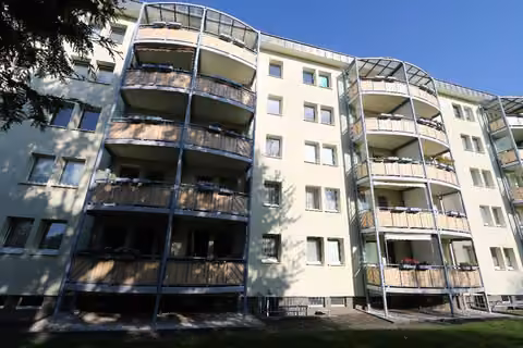 Zwangsversteigerung Eigentumswohnung in Zwickau, Eckersbach – Südansicht der Fassade mit Kennzeichnung der Balkoneinheit im Erdgeschoss.