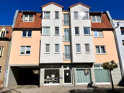 Zwangsversteigerung Eigentumswohnung in Schönebeck – Straßenseitige Ansicht des Wohn- und Geschäftshauses mit Markierung der Dachgeschosswohnung.