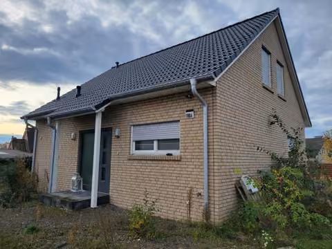 Zwangsversteigerung Einfamilienhaus in Hüllhorst, Oberbauerschaft – Schrägansicht des freistehenden Einfamilienhauses mit Verblendmauerwerk.