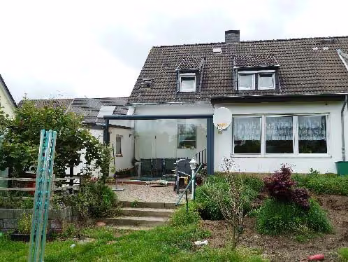 Zwangsversteigerung Zweifamilienhaus in Dormagen, Delhoven – Rückansicht des Zweifamilienhauses mit Garten und Anbauten.