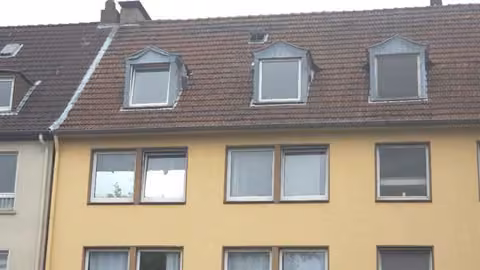 Zwangsversteigerung Eigentumswohnung in Gelsenkirchen, Schalke – Rückseitige Fassade des Gebäudes mit vermülltem hinteren Grundstücksbereich.
