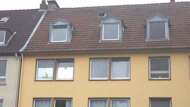 Zwangsversteigerung Eigentumswohnung in Gelsenkirchen, Schalke – Rückseitige Fassade des Gebäudes mit vermülltem hinteren Grundstücksbereich.