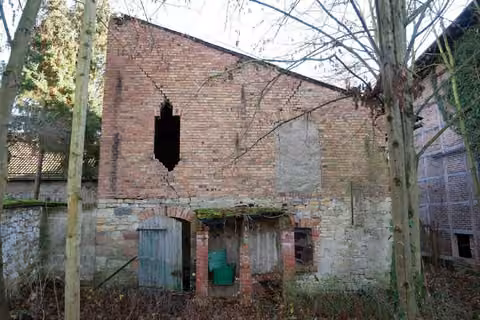 Zwangsversteigerung in Sömmerda, Schillingstedt – Westansicht des Nebengebäudes mit Ziegel- und Bruchsteinmauerwerk.
