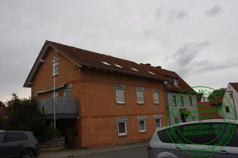 Zwangsversteigerung Einfamilienhaus in Lisberg – Straßenfront des Altbaus mit Eingangsbereich.