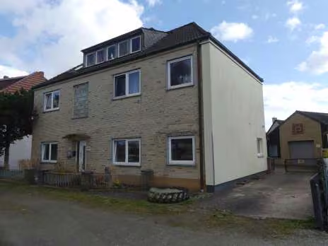 Zwangsversteigerung Zweifamilienhaus in Osterholz-Scharmbeck – Straßenansicht des Zweifamilienhauses mit Nebengebäude und Hofzufahrt.