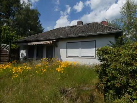 Zwangsversteigerung Einfamilienhaus in Lindwedel, Hope – Südliche Gartenansicht des Einfamilienhauses mit Terrasse und Walmdach.