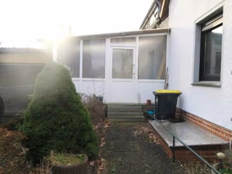 Zwangsversteigerung Mehrfamilienhaus in Walsrode, Benefeld – Rückseitige Fassade und Wintergarten von Westen.