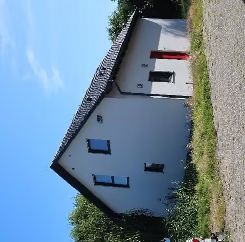 Zwangsversteigerung Zweifamilienhaus in Moormerland, Boekzetelerfehn – Außenansicht des Zweifamilienhauses von der Blumenstraße (Südwest).