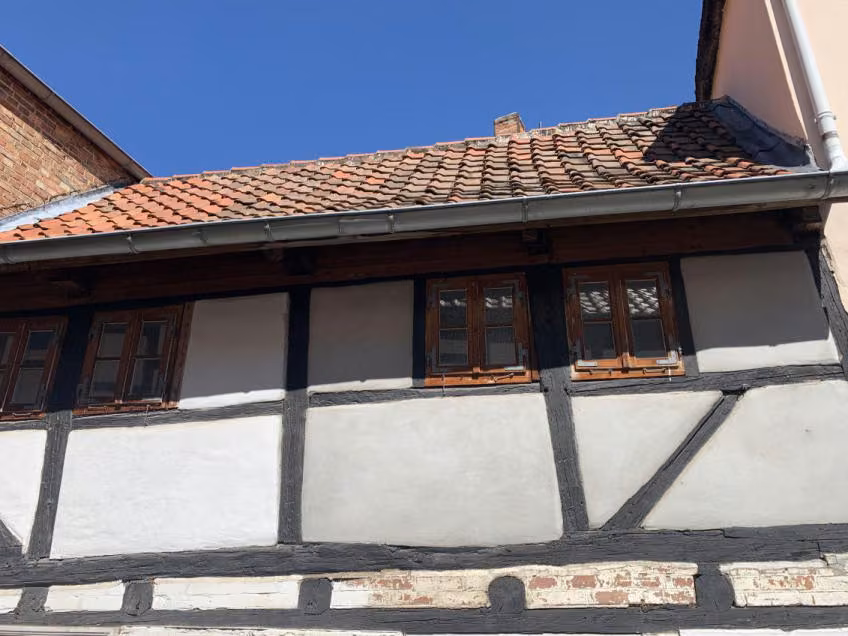 Zwangsversteigerung Einfamilienhaus in Hornburg – Wohnraum im Vorderhaus mit Holzdielen und Fenstern.
