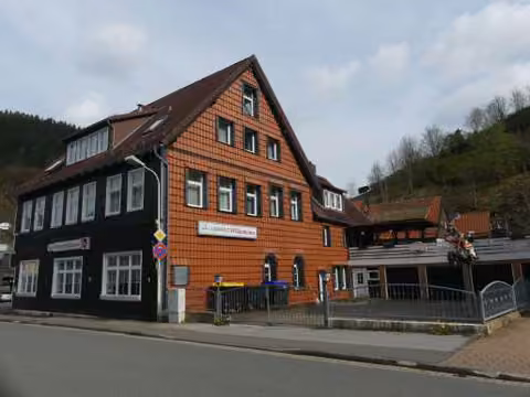 Zwangsversteigerung Grundstück in Wildemann – Südostansicht des Hotelgebäudes mit Giebel- und Eingangsbereich sowie Hofzufahrt.
