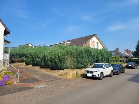 Zwangsversteigerung Einfamilienhaus in Hüllhorst, Büttendorf – Ostansicht des Wohnhauses mit Zufahrtsbereich.
