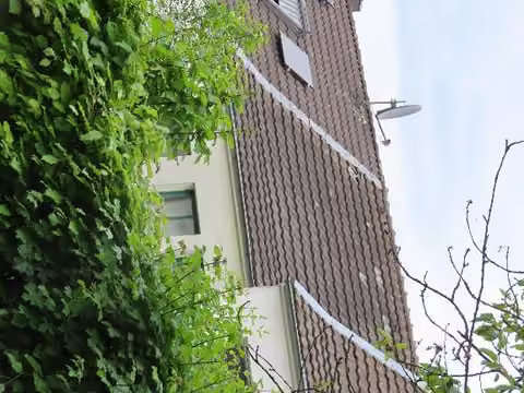 Zwangsversteigerung Reihenhaus in Aachen, Burtscheid – Gartenansicht und Dachbereich des Wohnhauses.