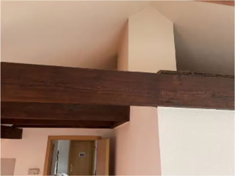 Zwangsversteigerung Eigentumswohnung in Köln, Neustadt-Süd – Wohnzimmer im ausgebauten Spitzboden mit Dachschrägen und Balken.