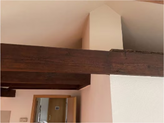 Zwangsversteigerung Eigentumswohnung in Köln, Neustadt-Süd – Wohnzimmer im ausgebauten Spitzboden mit Dachschrägen und Balken.