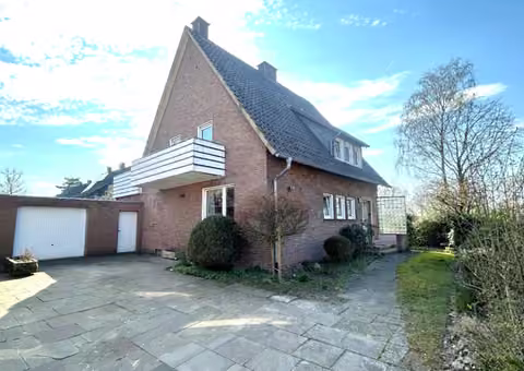 Zwangsversteigerung Einfamilienhaus in Warendorf – Außenansicht des Einfamilienhauses mit Vorplatz und Garage von der Straßenseite.