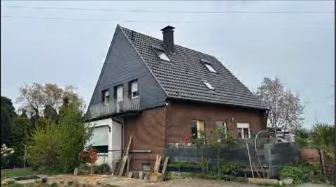 Zwangsversteigerung Einfamilienhaus in Wesel, Obrighoven – West-Ansicht des Gebäudes mit Garten- und Terrassenbereich.