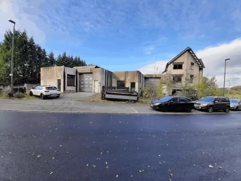 Zwangsversteigerung Gewerbe in Heiligenhaus, Hetterscheidt – Seitenansicht von links mit Sicht auf die maroden Hallenwände.