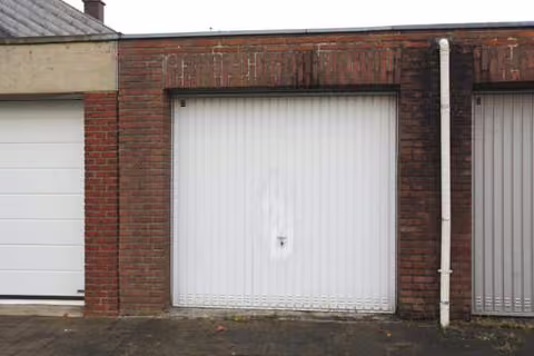Zwangsversteigerung Reihenhaus in Jüchen, Kernstadt – Frontansicht der Reihenmittelgarage mit Stahlschwingtor und Vorplatz.