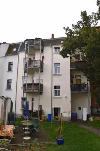 Zwangsversteigerung Eigentumswohnung in Plauen, Reißiger Vorstadt – Rückansicht des Gebäudes mit Balkonanlagen und Gartenfläche.