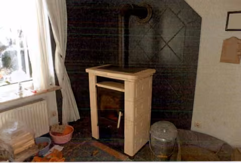 Zwangsversteigerung Gewerbe in Hadenfeld – Kaminofen im Wohnzimmer mit Fliesenrückwand.