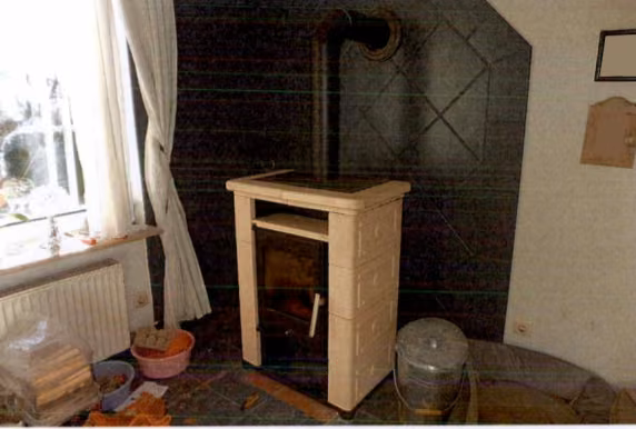 Zwangsversteigerung Gewerbe in Hadenfeld – Kaminofen im Wohnzimmer mit Fliesenrückwand.