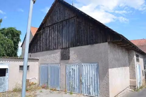 Zwangsversteigerung Zweifamilienhaus in Grabfeld, Wölfershausen – Rückansicht des Wohnhauses und des angrenzenden Gartengrundstücks.