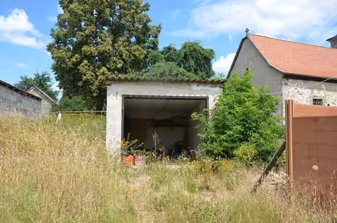 Zwangsversteigerung Zweifamilienhaus in Grabfeld, Wölfershausen – Freistehende Einzelgarage mit fehlendem Garagentor.