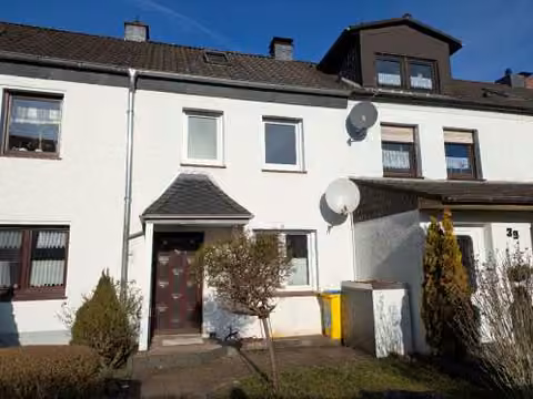 Zwangsversteigerung Reihenhaus in Dortmund, Kley – Vorderansicht des Reihenmittelhauses mit Hauseingangsbereich und Vorgarten.