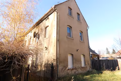 Zwangsversteigerung Einfamilienhaus in Zittau, Hirschfelde – Giebel- und Seitenansicht des Gebäudes mit sichtbarem Sanierungsbedarf an der Fassade.