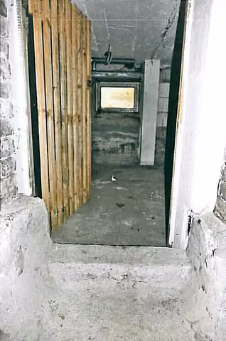 Zwangsversteigerung Büro in Oelsnitz/Vogtl. – Blick vom Kellerflur durch die Lattentür in die Lagereinheit Nr. 11.