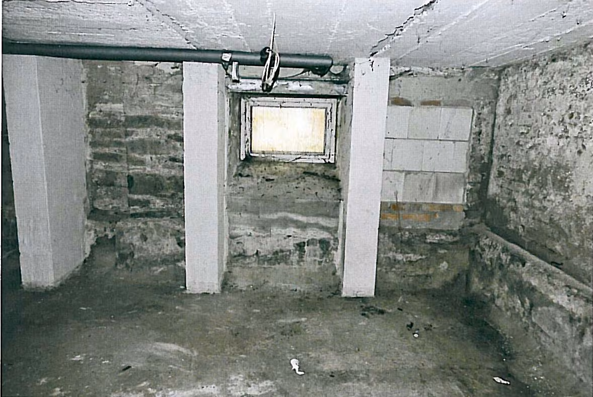 Zwangsversteigerung Büro in Oelsnitz/Vogtl. – Innenansicht der Lagereinheit Nr. 11 mit Kellerfenster und Wänden.