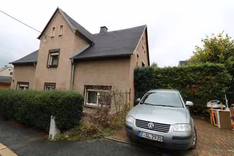 Zwangsversteigerung Zweifamilienhaus in Wilkau-Haßlau – Süd-Ansicht des Wohnhauses mit Pkw-Stellplatz und Vorgartenbereich.