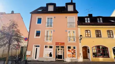 Zwangsversteigerung Eigentumswohnung in Moosburg an der Isar – Straßenfront des Wohn- und Geschäftshauses mit Hauseingang und Gewerbe