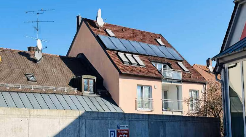Zwangsversteigerung Eigentumswohnung in Moosburg an der Isar – Rückansicht mit Dachgeschoss und Südbalkonen sowie Solaranlage