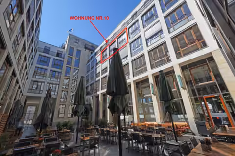 Zwangsversteigerung Eigentumswohnung in Berlin, Mitte – Innenhof der Wohn- und Geschäftsanlage mit Gastronomiebereich.
