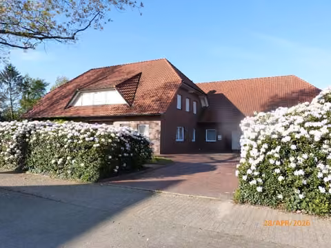 Zwangsversteigerung Einfamilienhaus in Dinklage – Vorderansicht des Einfamilienhauses mit Vorfahrt und gepflegtem Vorgarten.