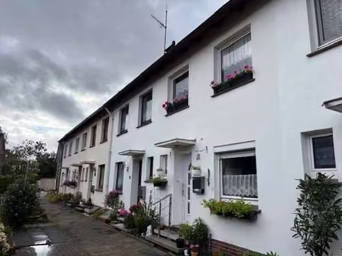 Zwangsversteigerung Reihenhaus in Varel – Straßenansicht der Reihenhauszeile mit Hauseingang Rüstringer Straße 20.